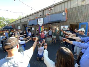 Group of people holding steins outside of Foundation brewing